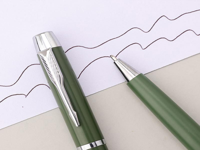 Como a seleção de materiais afeta a longevidade e a confiabilidade da caneta esferográfica?